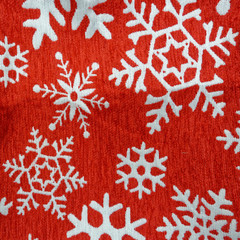 white snow flakes shapes on red fabric, winter background