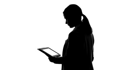 Silhouette of woman using tablet, reading business news, modern technologies