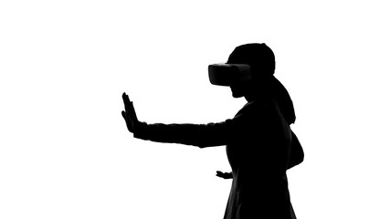 Silhouette of woman in vr headset playing martial arts game, leisure time