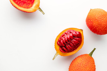 Gac fruit on a white background, creative flat lay food concept