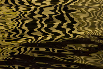 Waves on the water forming stripes similar to the texture of velvet, the alternation of gold and...