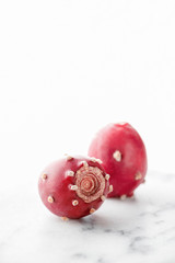 Prickly pear fruit on a white marble background, creative food concept, prickly pear cactus