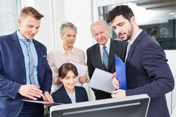 Gruppe Gesch&auml;ftsleute blickt auf einen Computer