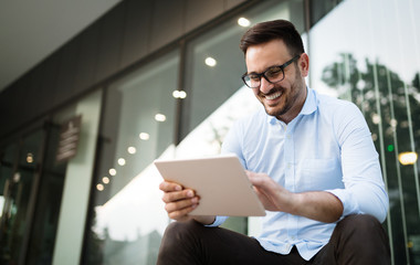 Businessman wearing glasses holding tablet and smiling
