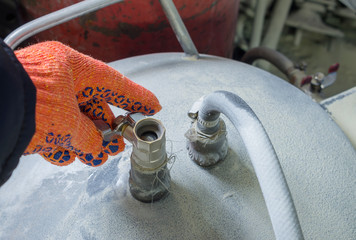 The hand opens the compressed air cylinder valve