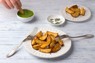 Baked potatoes with kale pesto sauce on a light blue background, selective focus. Delicious vegan homemade food