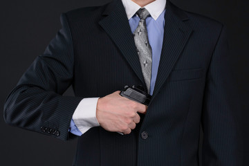 man in suit pull the gun out of his jacket