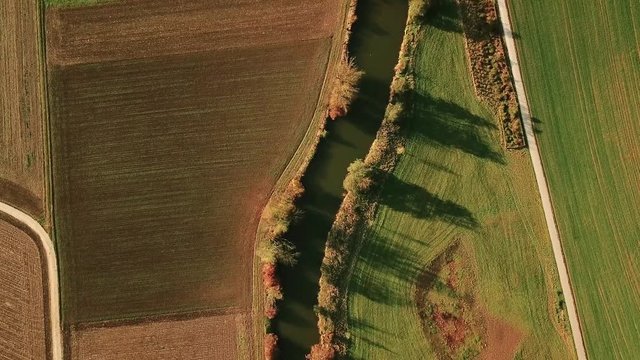 Aerial tracking shot of river in autumn landscape