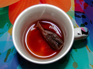 Unfinished tea in a mug with a tea bag.