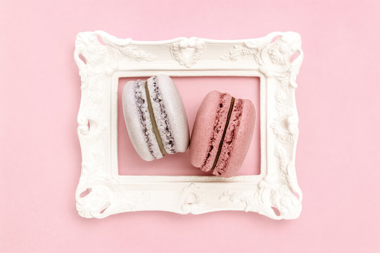 Lavender and pink macaroons in a white frame.
