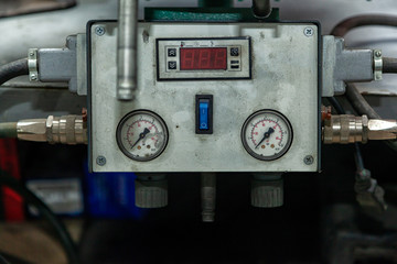 Fototapeta na wymiar Close-up of a vulcanizer apparatus with buttons and screens in a car repair shop. Control panel with pressure sensors and indicator...