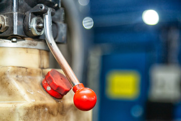 Close-up red new car lift lever in a car repair shop. Apparatus for Pressure Relief