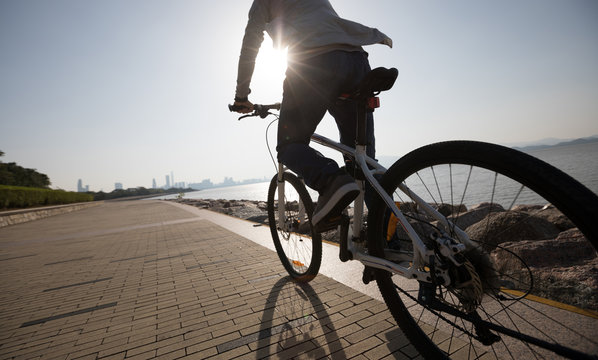 Silhouette cyclist riding bike in the sunrise coast road