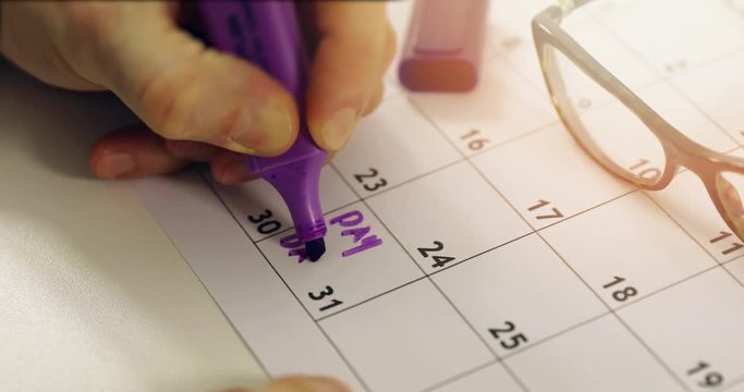 payday - hand with marker circle the day of salary