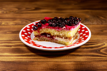 Tasty cheesecake with black currant on wooden table