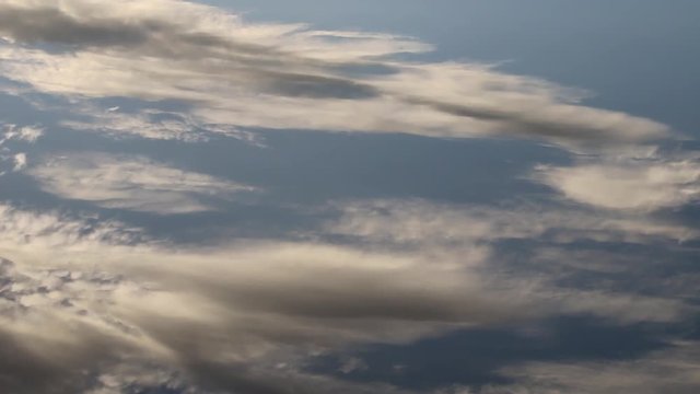 Magical inconstancy. Moire waves of clouds are reflected in the calm mirror water. The changeability and fluidity of shapes and colors, the play of colors
