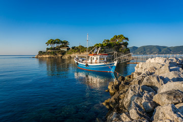 Blue boat parked in the Laganas dock with the Cameo island in the back