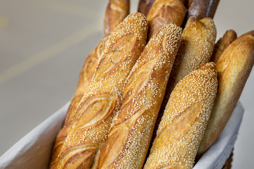 Traditional crusty French bread baguette in basket at bakery. Fresh organic pastry at local market. France cuisine background