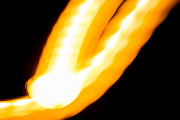 Bright fiery trail of light on a dark background