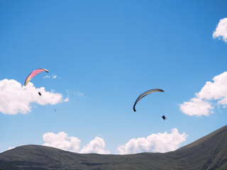 paragliders against the blue sky and mountains