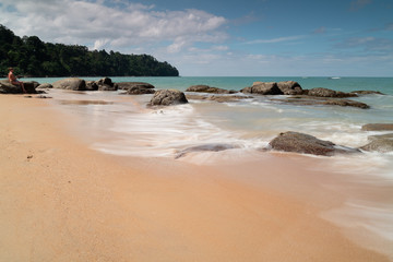 Khao Lak beach, long exposure of waves breaking on rocks and the shore