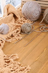 Woolen yarn and fabric on the window sill. Beautiful view outside the window - winter scenery and snow.