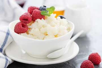 Rice porridge or pudding with fresh raspberry  in a white  bowl for a breakfast. 