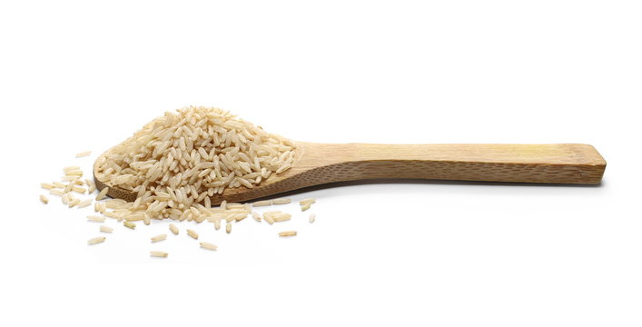 Integral brown long rice pile with wooden spoon isolated on white background