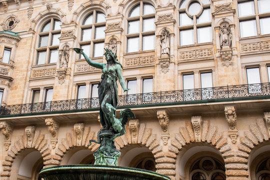 Detail of ornate statue of Woman in fountain with large  ancient building in background