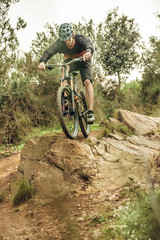 Obraz na płótnie Canvas Mountain bike rider jumping rock drop