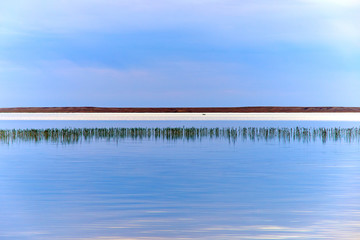 Beautiful landscape with the lake. Smooth lake surface after the sunset.
