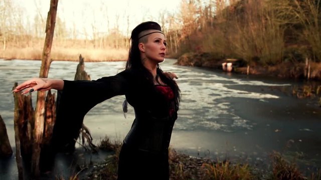 Beautyful Viking woman standing on frozen sea with arms outspread