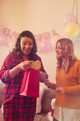 Pregnant woman celebrating baby shower party with friends.