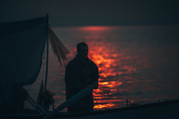 Sun goes down while fisherman throws his fishnet to collect fishes