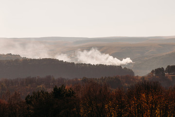 Fire in the forest in the hilly terrain in autumn