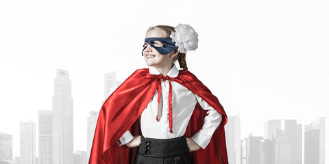 Obraz premium Girl power concept with cute kid guardian against cityscape back