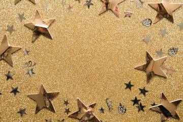 Fototapeta na wymiar Gold star sparkle party confetti on a gold glitter background