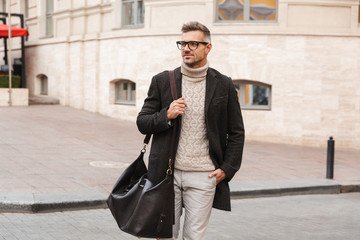 Handsome man wearing a coat walking