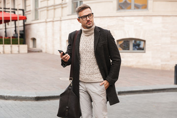 Handsome man wearing a coat walking
