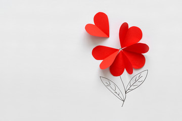 Valentines day card. Red paper heart shape flower on white paper background. Paper cut style and...