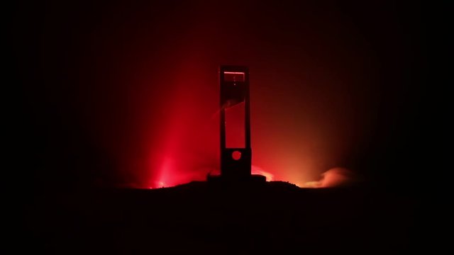 Horror view of Guillotine. Human at guillotine on a dark foggy background. Execution concept