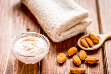 spa concept with almond nuts and scrub on wooden background