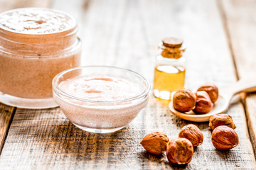 cosmetic set with hazelnut scrub on table background