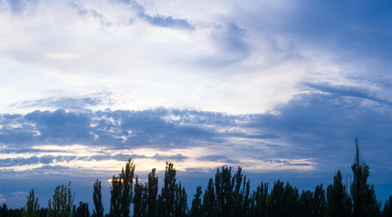 Landscape with dramatic light - beautiful golden sunset with saturated sky and clouds.