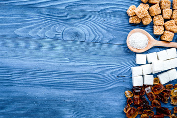 lumps and sanding sugar for sweets on blue kitchen table backgro