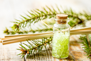 Bottles of sea salt and fir branches for aromatherapy and spa on