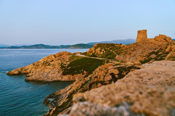 Fototapeta na wymiar Golden rocks in Ille Rouse near lighthouse Pietra during sunset in Corsica