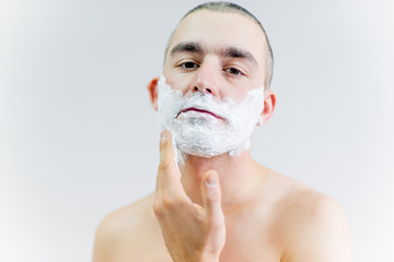 man is shaving his face in a bathroom