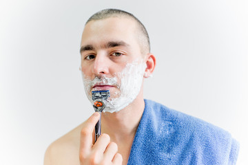 man is shaving his face in a bathroom