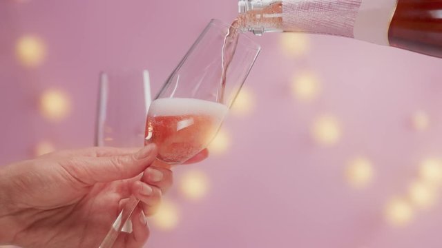 closeup slow motion woman serve a glass of pink rose sparkling wine